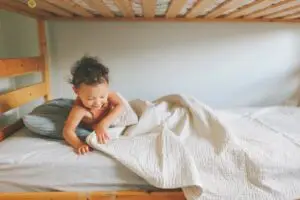 child climbing out of their toddler bed- baby sleep consultant